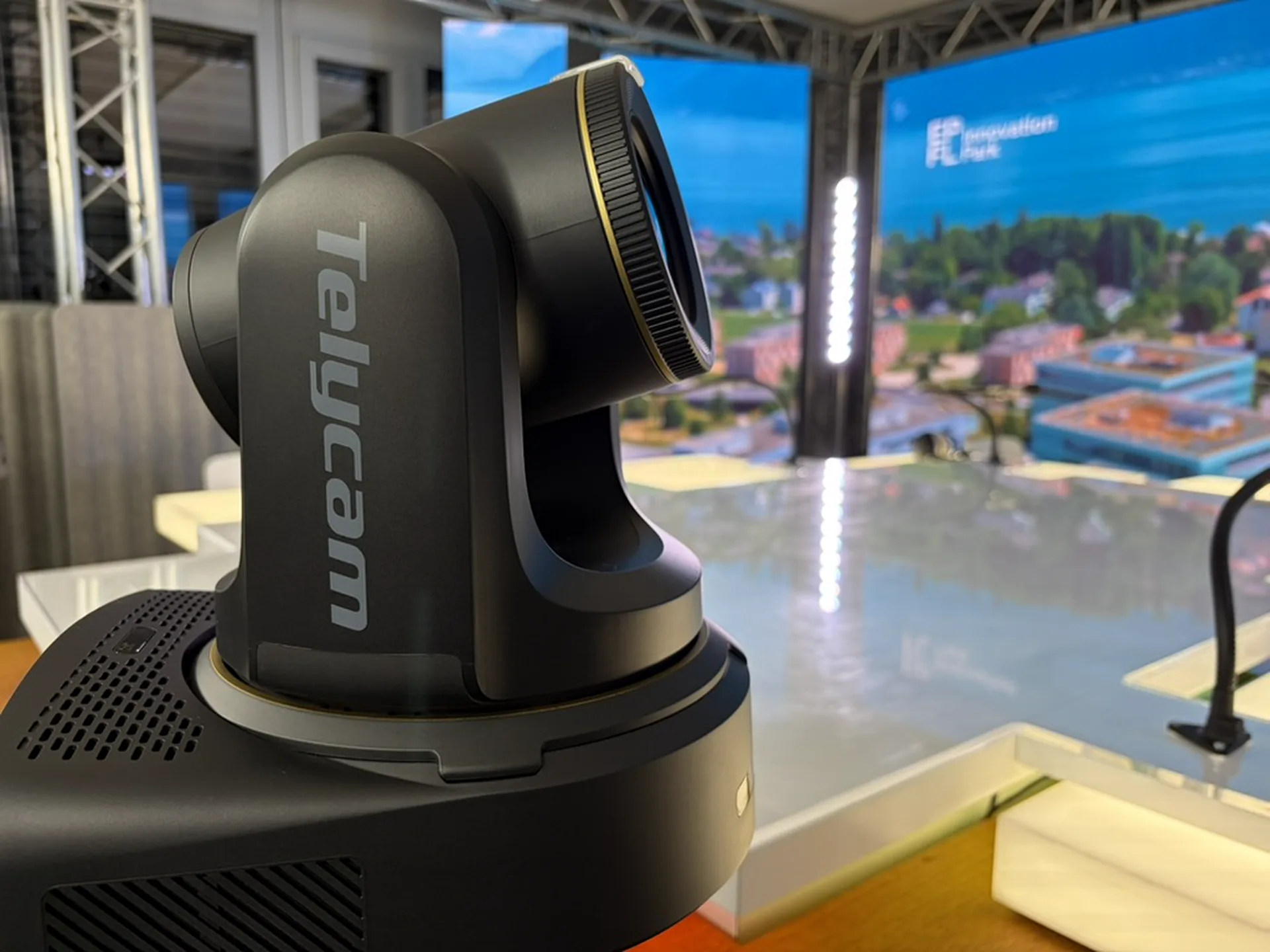 Caméra de broadcast Telycam au premier plan, avec le plateau et les écrans du studio en arrière-plan